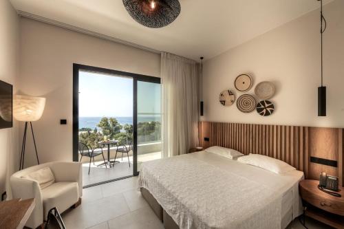um quarto com uma cama, uma cadeira e uma janela em Anemi Hotel & Suites em Pafos