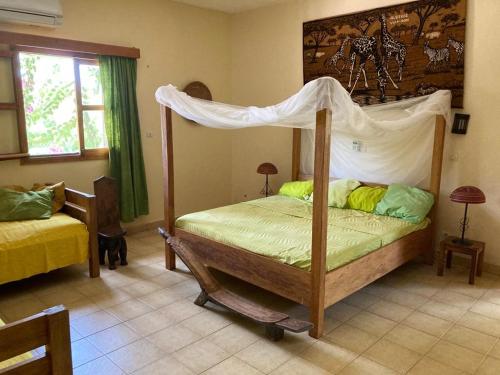 ein Schlafzimmer mit einem Himmelbett in der Unterkunft Villa Rose in Bobo-Dioulasso