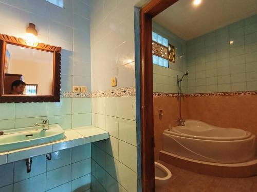 Warji House 2 Bisma في أوبود: حمام مع حوض ومغسلة ومرآة