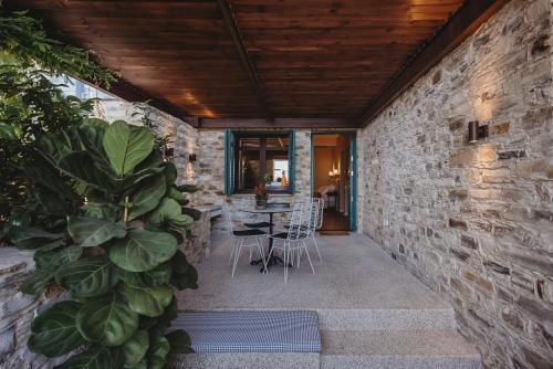 a stone walled patio with a table and chairs at Andama Luxury Suites in Pano Lefkara