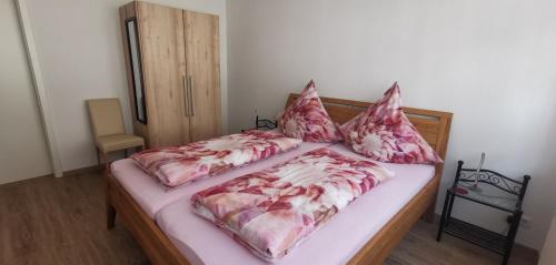 a bed with pink and white sheets and pillows at Silvia Hüls in Kröv