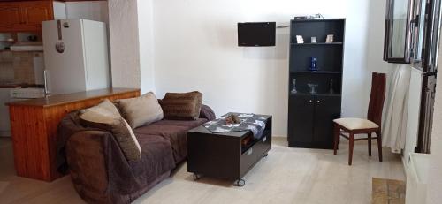 ein Wohnzimmer mit einem Sofa und einem Kühlschrank in der Unterkunft Ευρύχωρο και άνετο διαμέρισμα στην Ιτέα Joanna's Apartment in Kírra