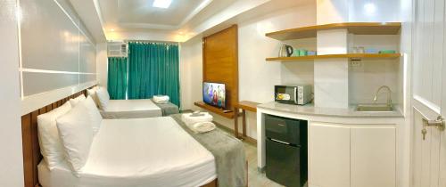a small room with a bed and a kitchen at Cozy Unit at the heart of Balanga City in Balanga