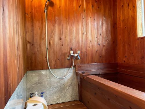 a bathroom with a shower in a wooden wall at 旅館 竹屋 Takeya in Yufu