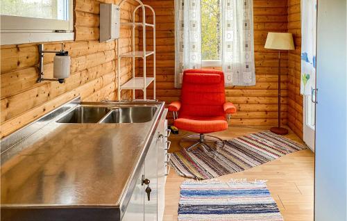 une cuisine avec un évier et une chaise rouge dans l'établissement Cozy Home In Ambjrnarp With Kitchen, à Ambjörnarp