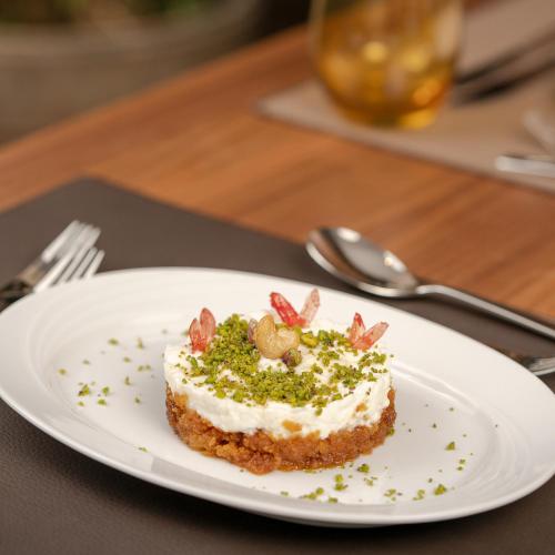 a piece of cake on a plate on a table at Grand Millennium Al Seef Basra in Al Başrah