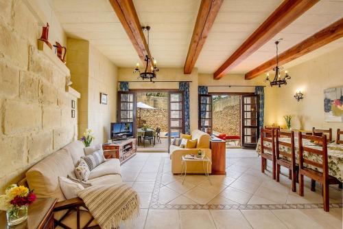 a living room with a couch and a tv at Razzett ta' Leli Holiday Home in Xagħra