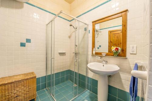 a bathroom with a sink and a shower at Razzett ta' Leli Holiday Home in Xagħra
