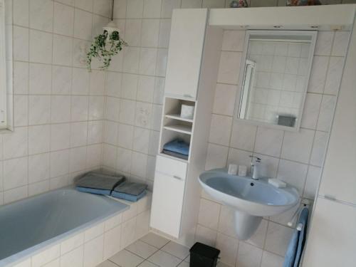 a bathroom with a bath tub and a sink at Fewo1926 in Mertesdorf