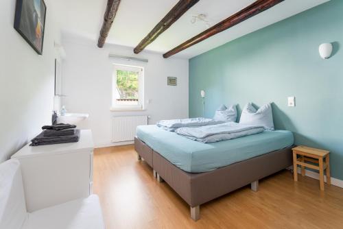 a bedroom with a bed with blue walls and a wooden floor at Haus am Wilde Aar in Medebach