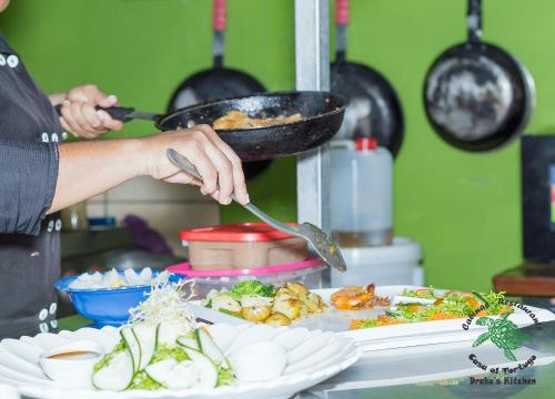 a person holding a spatula over a plate of food at Casa el Tortugo in Drake