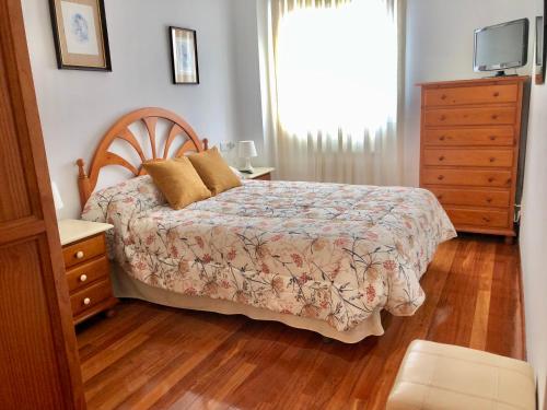 a bedroom with a bed and a dresser and a window at PISO con GARAJE en AVILES in Avilés