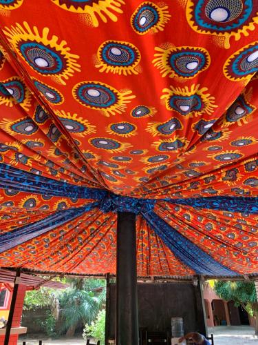 an orange umbrella with blue and yellow designs on it at The Gunjur Project Lodge in Gunjur