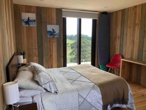 a bedroom with a bed and a large window at Casa de campo Matanzas in Navidad