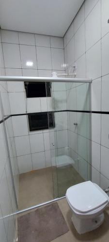 a bathroom with a glass shower with a toilet at Pousada Sol do Jalapão in Ponte Alta do Norte