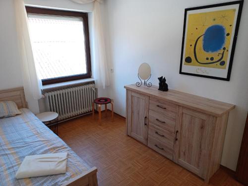 a bedroom with a bed and a dresser and a window at Fewo Frizzi in Richelbach