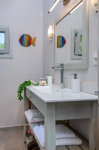 a bathroom with a sink and a mirror at Acacia APT by Aglaia V in Vlachopoulátika