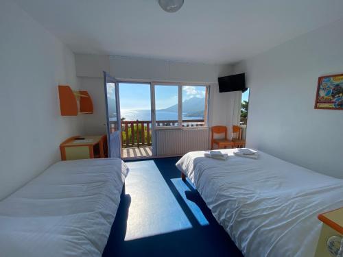 two beds in a room with a balcony at Village Vacances Lou Castelet in Théoule-sur-Mer
