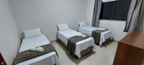 a room with three beds and a window at Pousada Sol do Jalapão in Ponte Alta do Tocantins