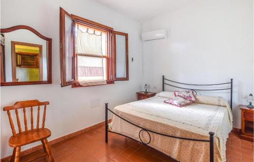 1 dormitorio con cama, silla y espejo en Pet Friendly Home In Sedini With Kitchen, en Sedini