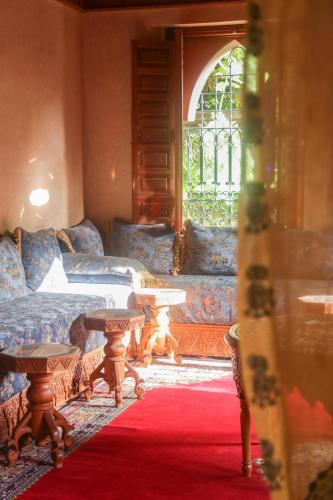 a living room with a couch and tables on a red carpet at Villa Taj Sofia & Spa in Marrakech