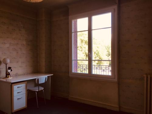 Habitación con escritorio y ventana. en Comfortable Paris 2, en Vitry-sur-Seine