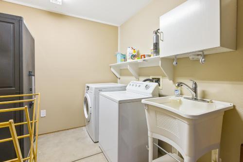 a small kitchen with a sink and a washing machine at Berry House in Arroyo Grande