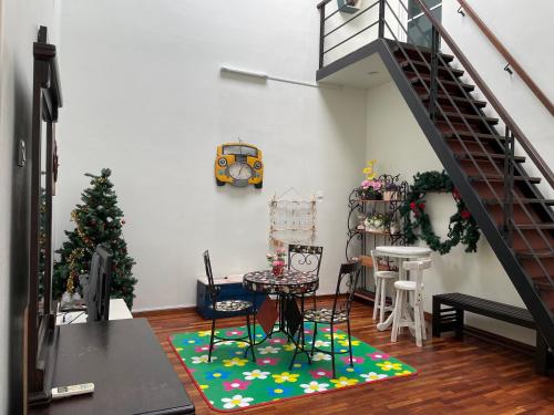Sala de estar con mesa y árbol de Navidad en Shamrock Villas Corner OR Seaview OR Standard, en Batu Ferringhi