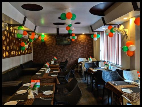 a restaurant with tables and chairs and balloons on the ceiling at THE PRESTIGE HOTEL & CONVENTION in Rourkela