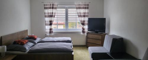Una pequeña habitación con una cama y una ventana. en Apartmán DANY Hanušovice, en Hanušovice