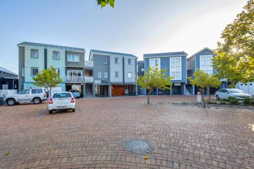 a car parked in a parking lot in front of buildings at Thesen Harbour Town Apartments @ Beautiful Knysna Villas in Knysna