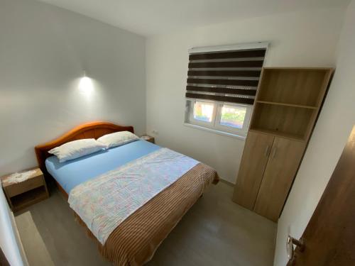 um pequeno quarto com uma cama e uma janela em Kod čika brke em Vrdnik