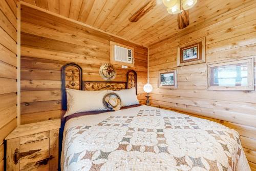 een slaapkamer met een bed in een blokhut bij Rock of Ages Cabin at Amazing Grace Canyon in Luckenbach
