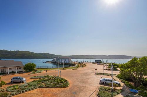 a parking lot next to a body of water at Thesen Harbour Town Apartments @ Beautiful Knysna Villas in Knysna