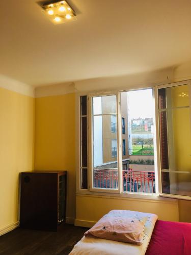 une chambre avec un lit et une fenêtre dans l'établissement Comfortable Paris 3, à Vitry-sur-Seine
