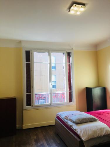 - une chambre avec un lit et une fenêtre avec des chaises dans l'établissement Comfortable Paris 3, à Vitry-sur-Seine