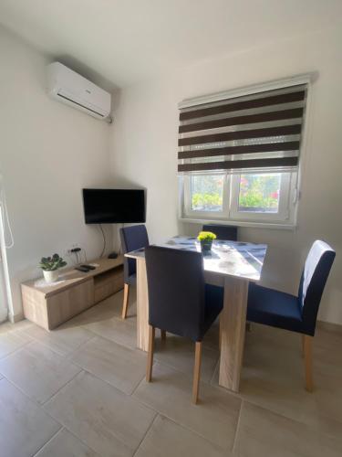 a dining room with a table and chairs and a television at Kod čika brke in Vrdnik