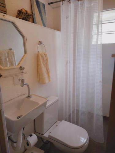 uma casa de banho branca com um WC e um lavatório em CasaMágica SP em São Paulo