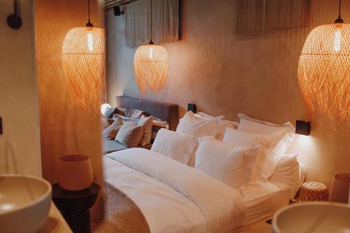 a bedroom with a large bed with white pillows at Comme chez Soye - Private Wellness in Soye