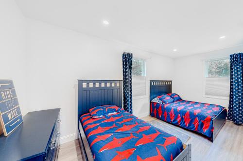 a bedroom with two beds and a table and windows at Coastal Gem in York
