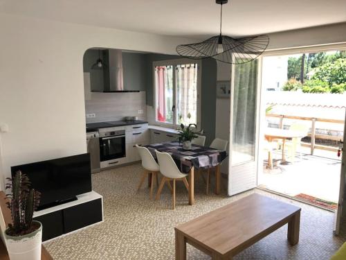 a kitchen with a table and a dining room at Maison à 500 mètres de la plage in Saint-Trojan-les-Bains