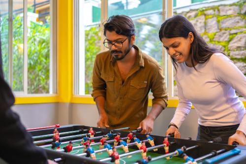 a man and woman playing a game of table football at The Hosteller Munnar in Munnar