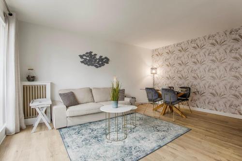 多維爾的住宿－Les Caravelles - Trois Pièces - Deauville Centre，客厅配有沙发和桌椅