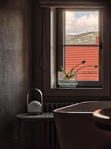 a bathroom with a tub and a window with a view at Jaskółka Dom i SPA in Szklarska Poręba