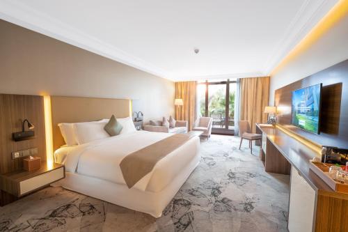 a hotel room with a bed and a television at Grand Millennium Al Seef Basra in Al Başrah