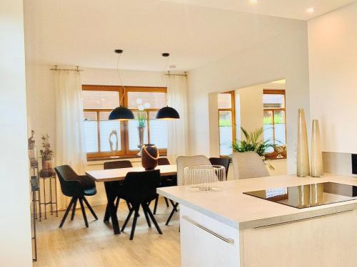 a kitchen and living room with a table and chairs at SchlaWenke- Hier schlafen Sie gut in Herzlake