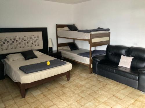 a bedroom with a bed and a couch and a bed and a chair at Casa de Huéspedes, Casa Sol, Hospedaje para Grupos in Aguascalientes