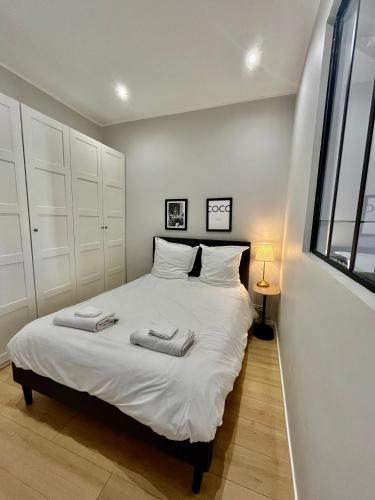 une chambre avec un lit blanc avec deux serviettes dessus dans l'établissement Nouveau Loft: vieille-ville, musée Picasso, marché, à Antibes