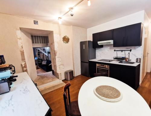 een keuken met een witte tafel en een wit aanrecht bij Loft atypique au calme avec cour privative in Bourges