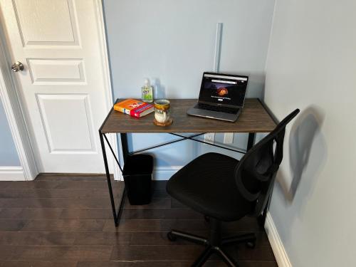 a desk with a laptop and a chair on it at Chic, Spacious Home You'll Love in Markham
